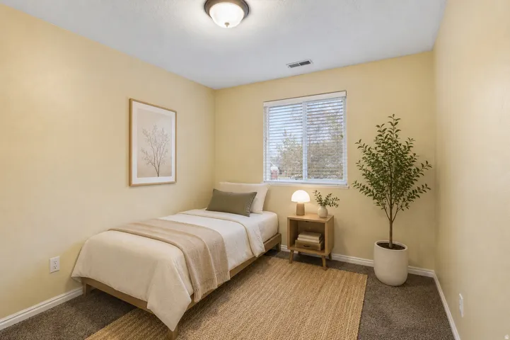 Window with blinds, wall-to-wall carpeting, overhead flush mount lighting, and neutral wall tones