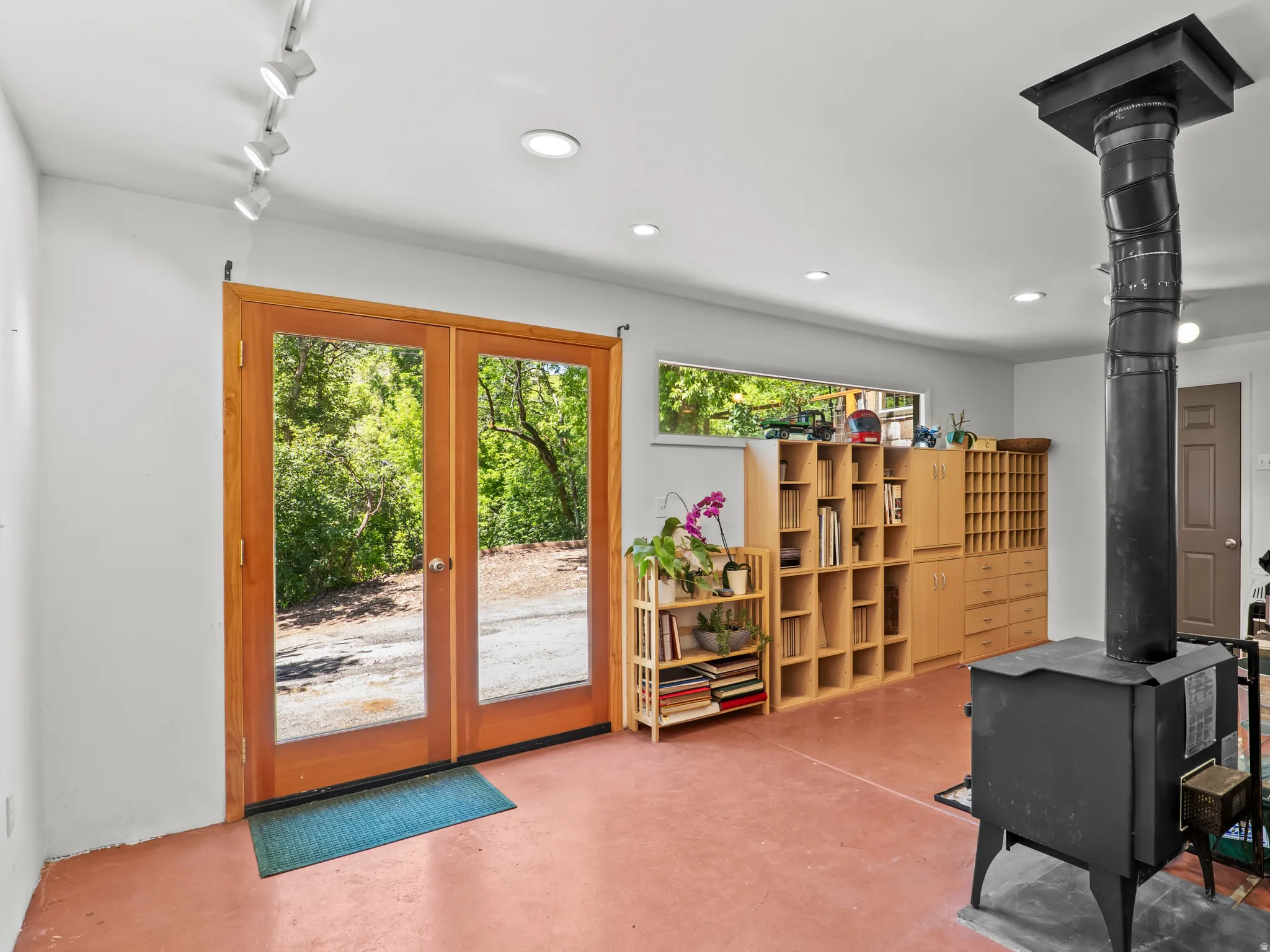 Stand only studio featuring a central wood-burning stove,  and extensive built-in cabinetry with open shelving and drawers Features beauiful  large glass door for an indoor/outdoor experience