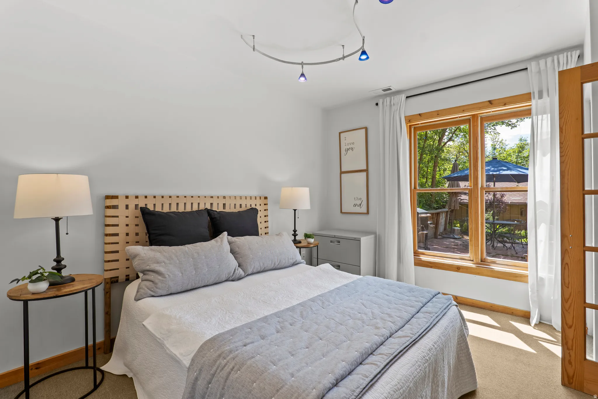 Bright room featuring a large window with natural wood trim and carpeted flooring