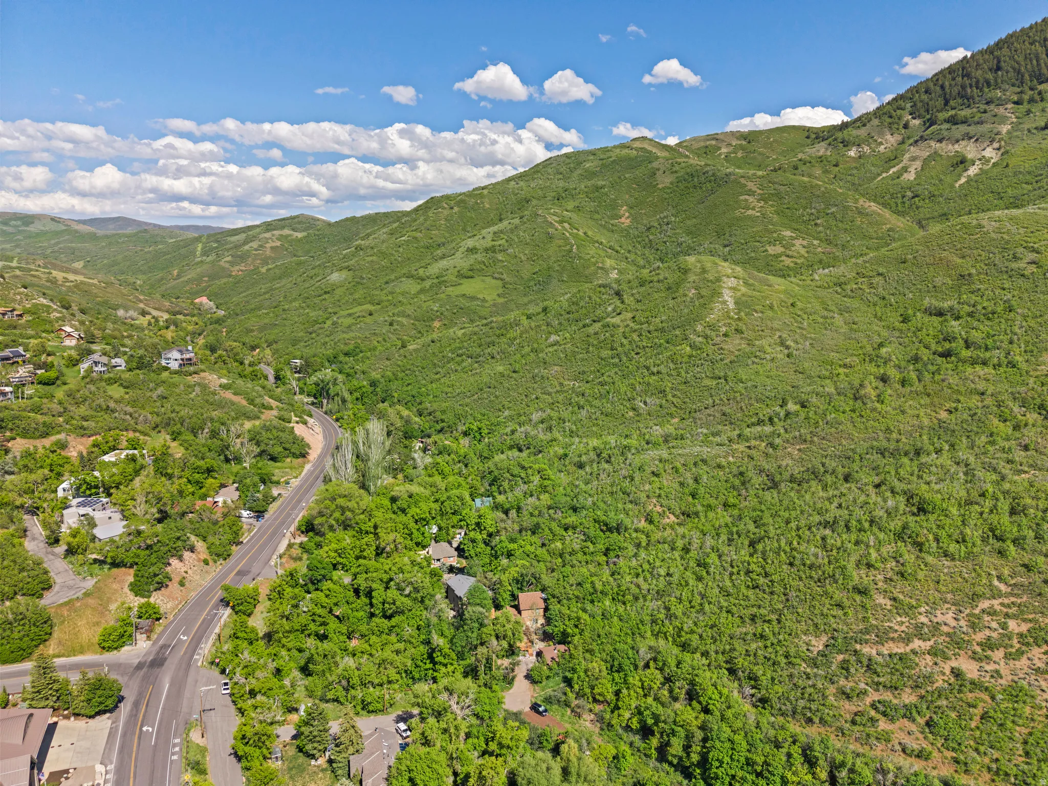 Expansive aerial scene featuring lush green canyon and mountains