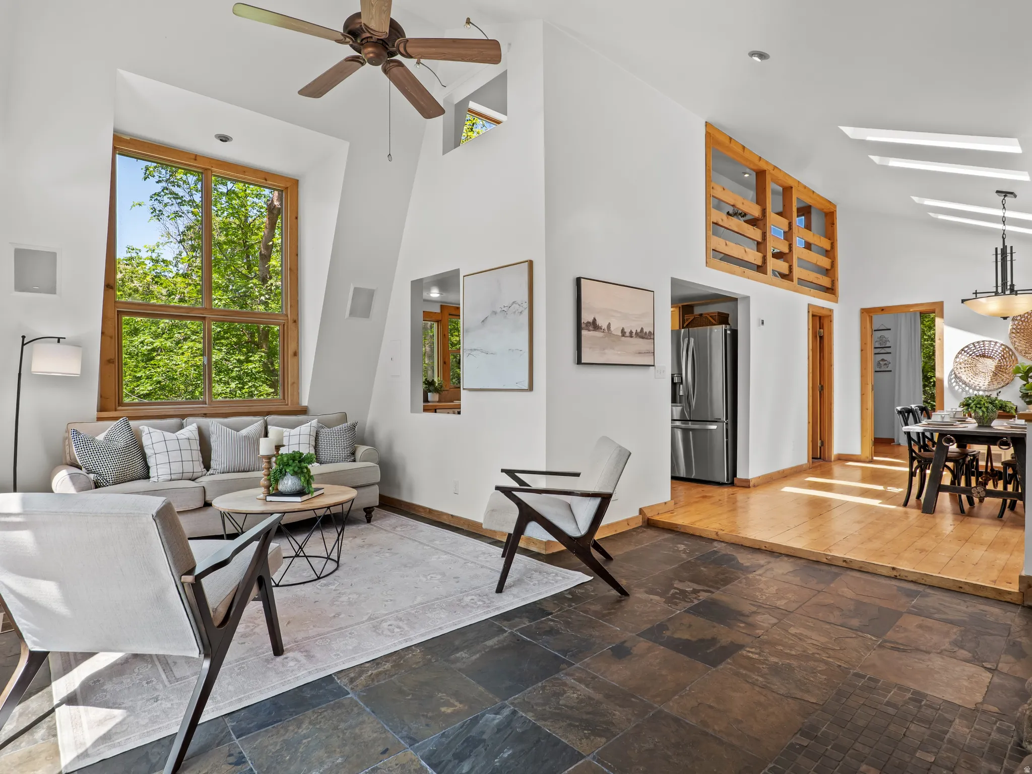 Open-concept living space featuring high vaulted ceilings with skylights