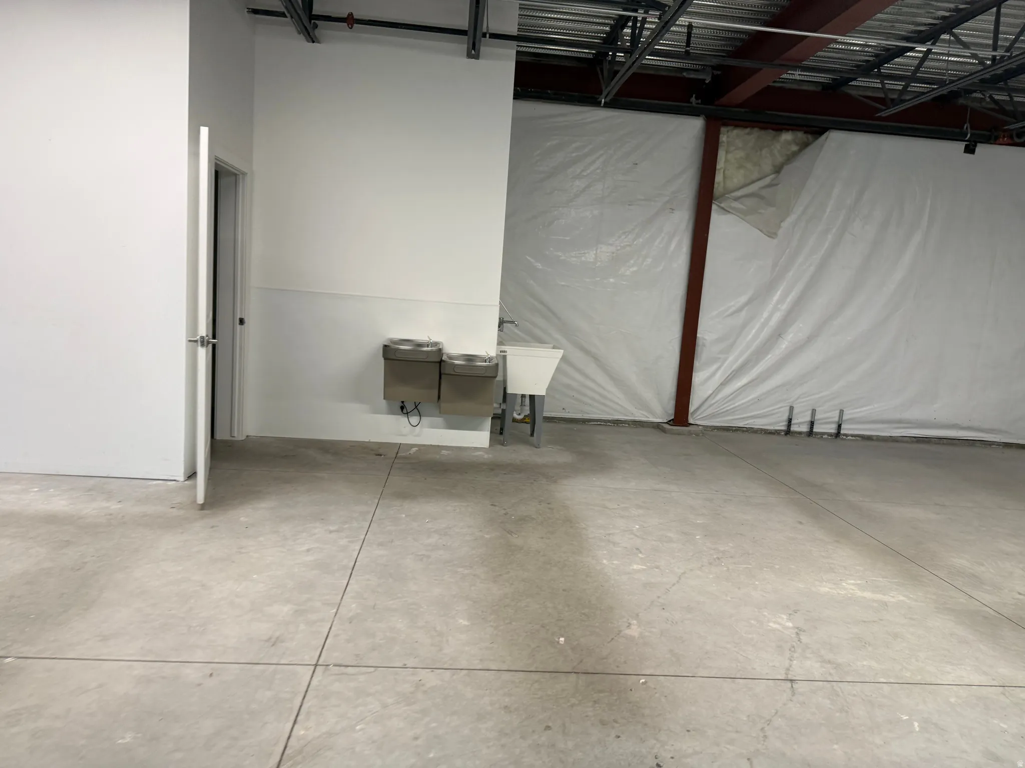 Concrete flooring with exposed ceiling joists and structural beams