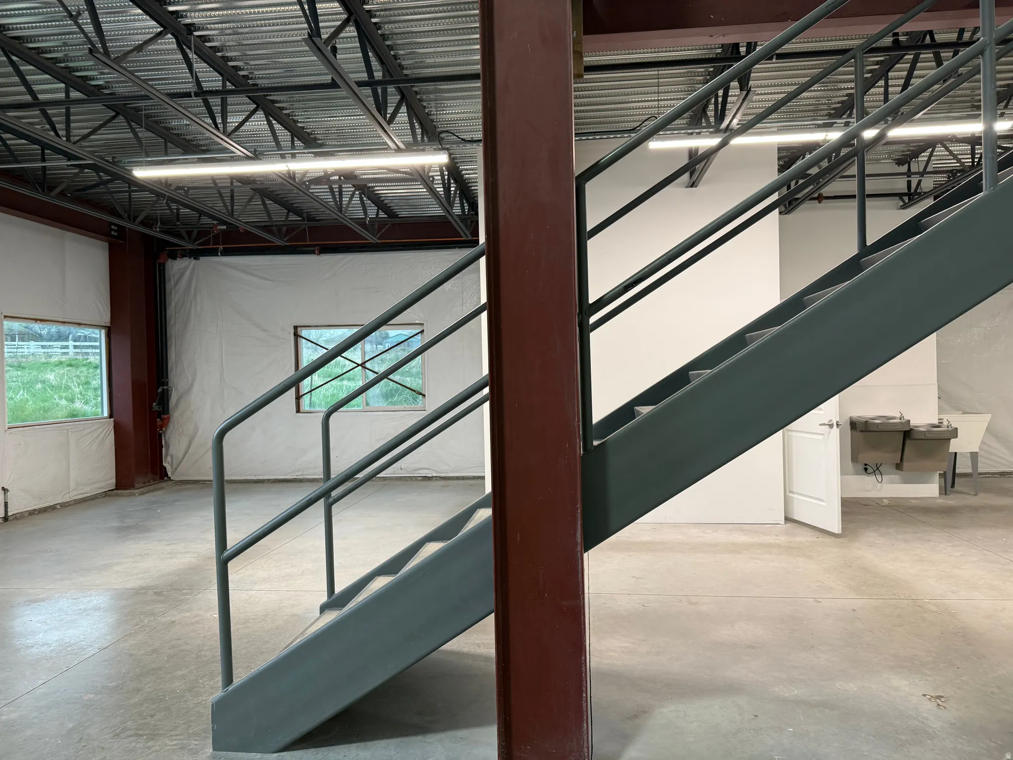 Industrial-style staircase with metal railings and exposed structural beams