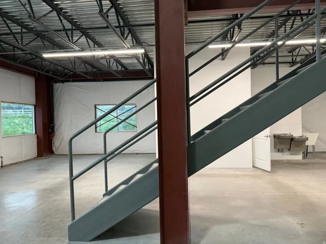 Industrial-style staircase with metal railings and exposed structural beams