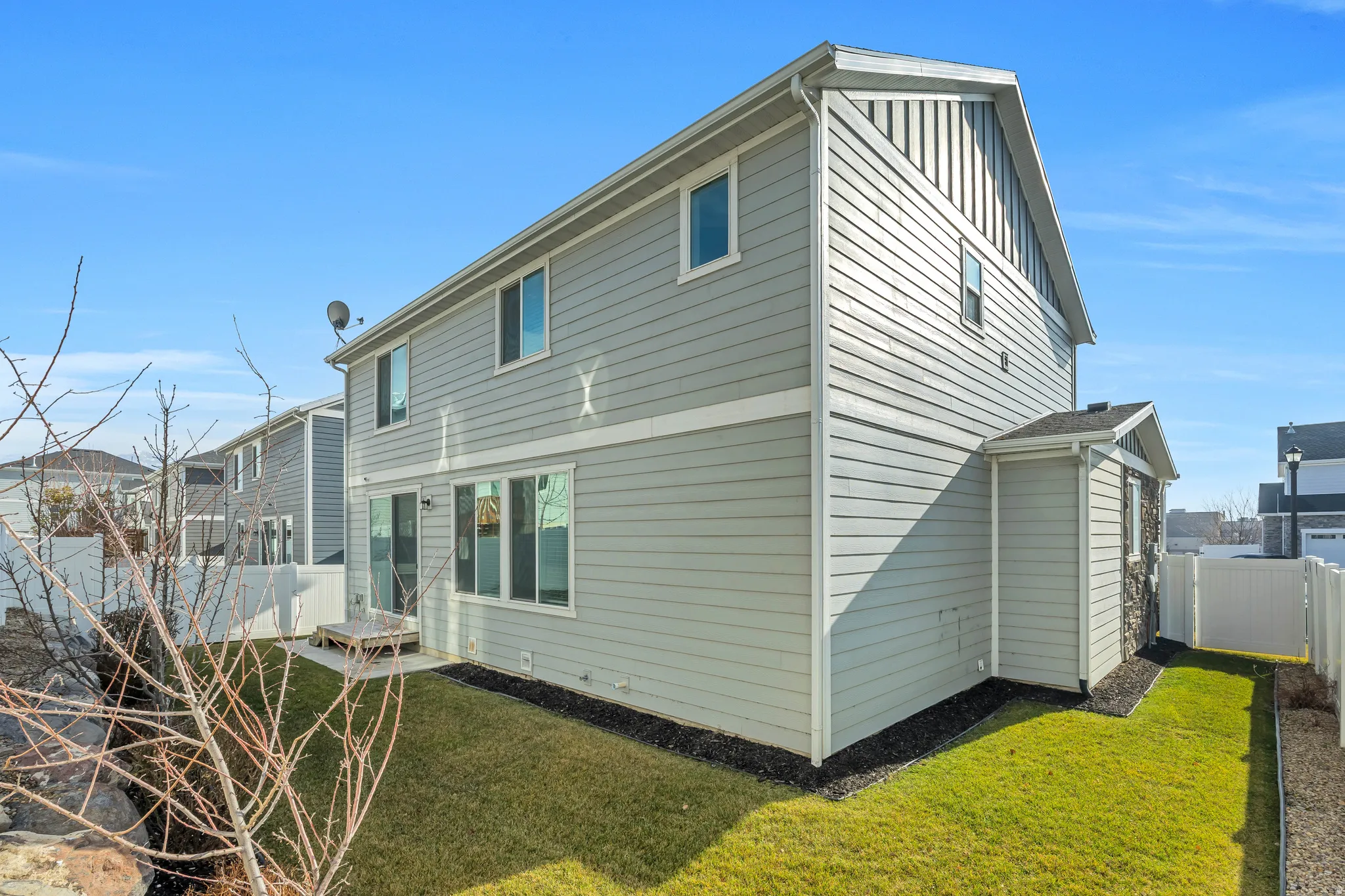 Two-story exterior with light gray horizontal siding and board and batten accents