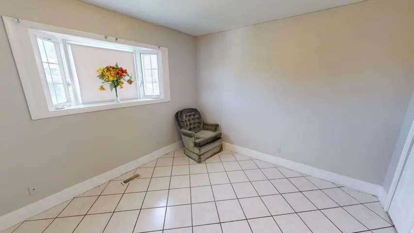 Bay window with white trim, light-colored walls, and diagonal tile flooring