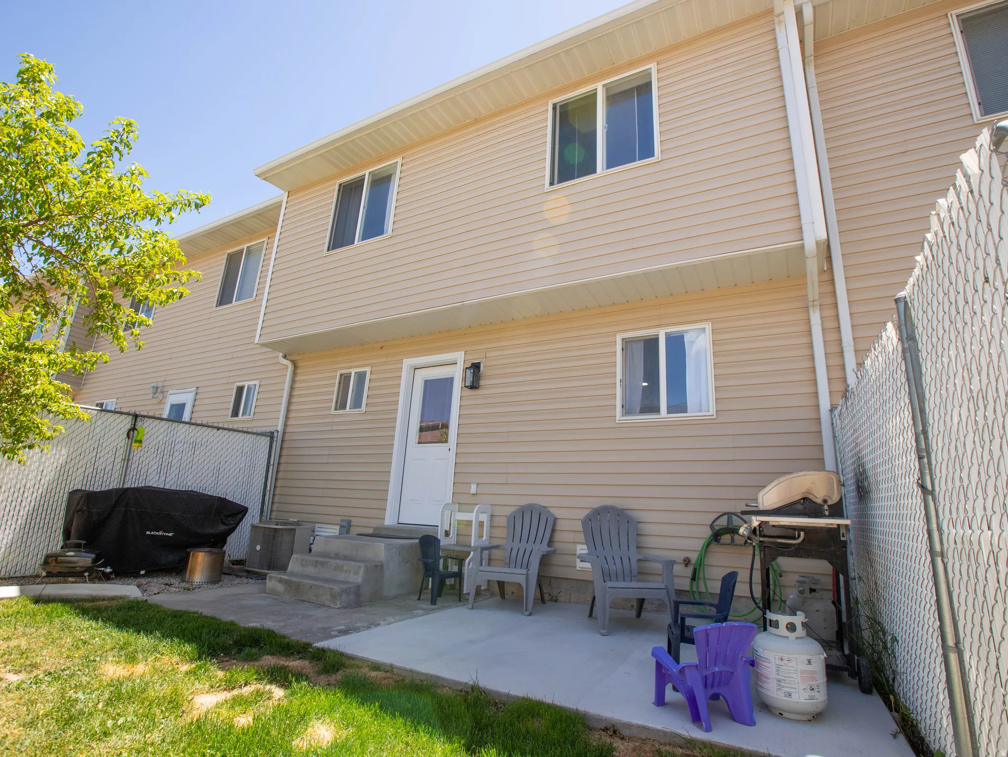 Rear exterior featuring light-toned horizontal siding and multiple windows