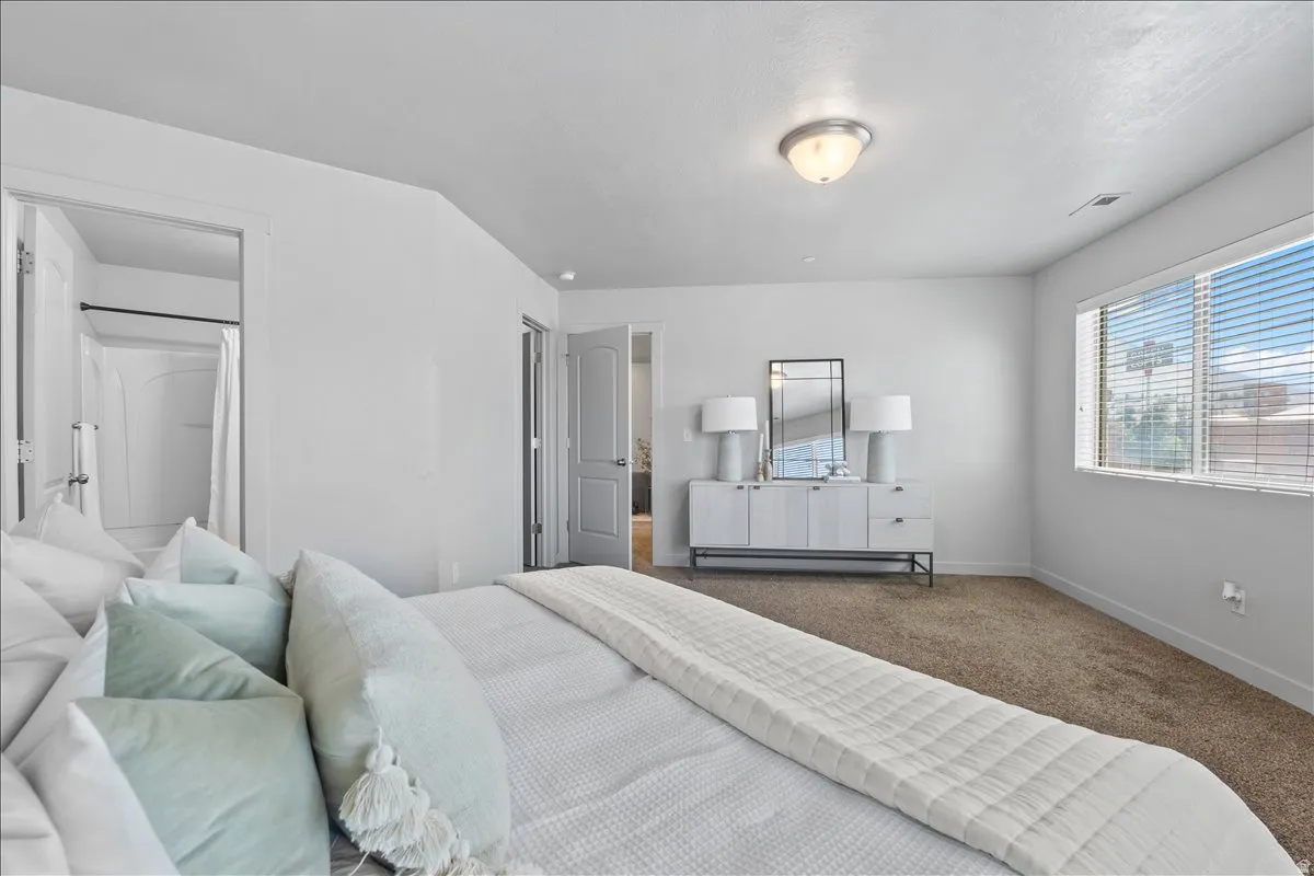 Carpeted room with white walls, a large window with blinds, and an overhead flush mount light fixture