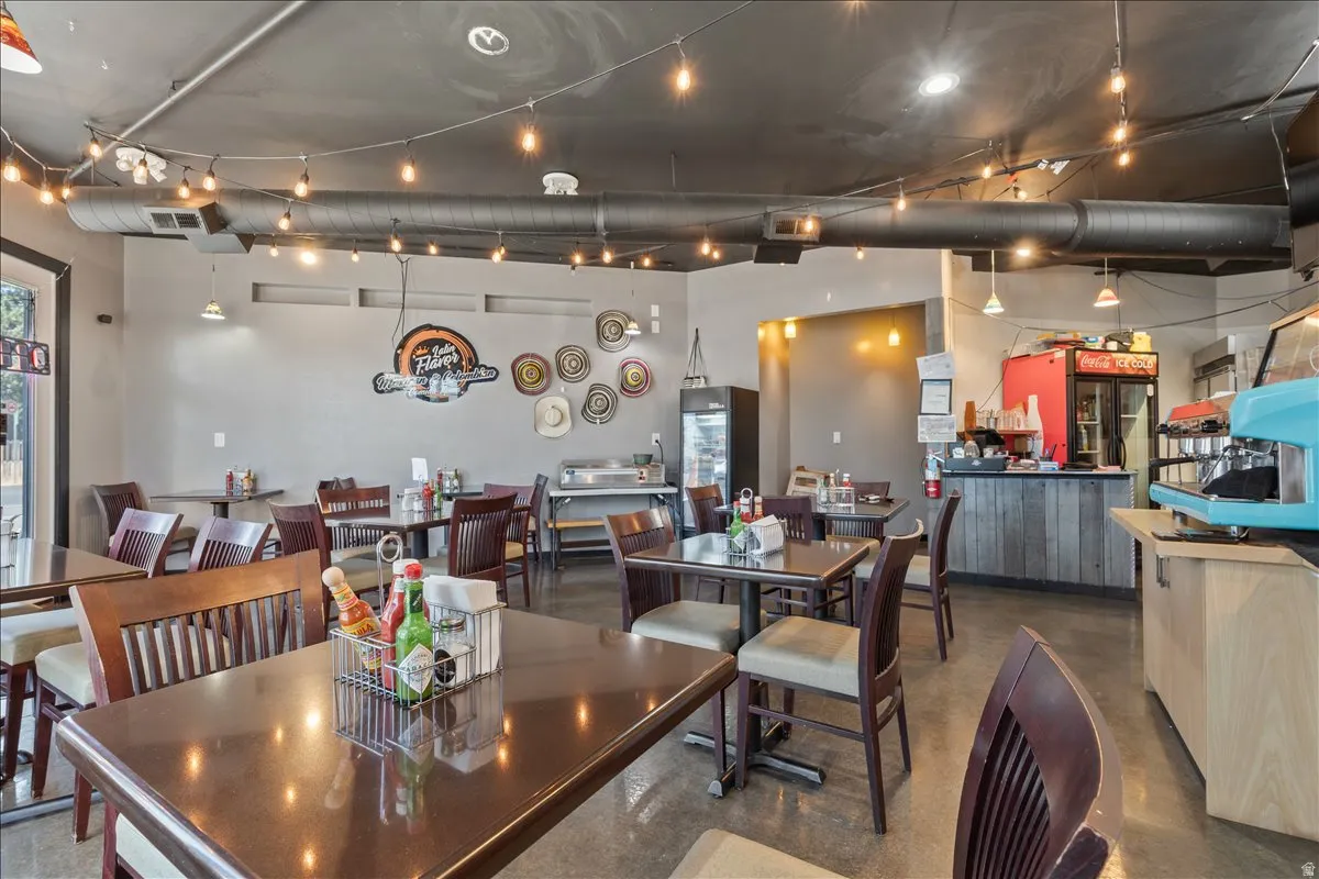 Open commercial space with string lighting and exposed ceiling ductwork