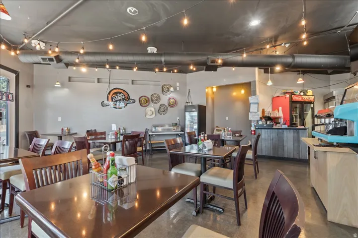 Open commercial space with string lighting and exposed ceiling ductwork
