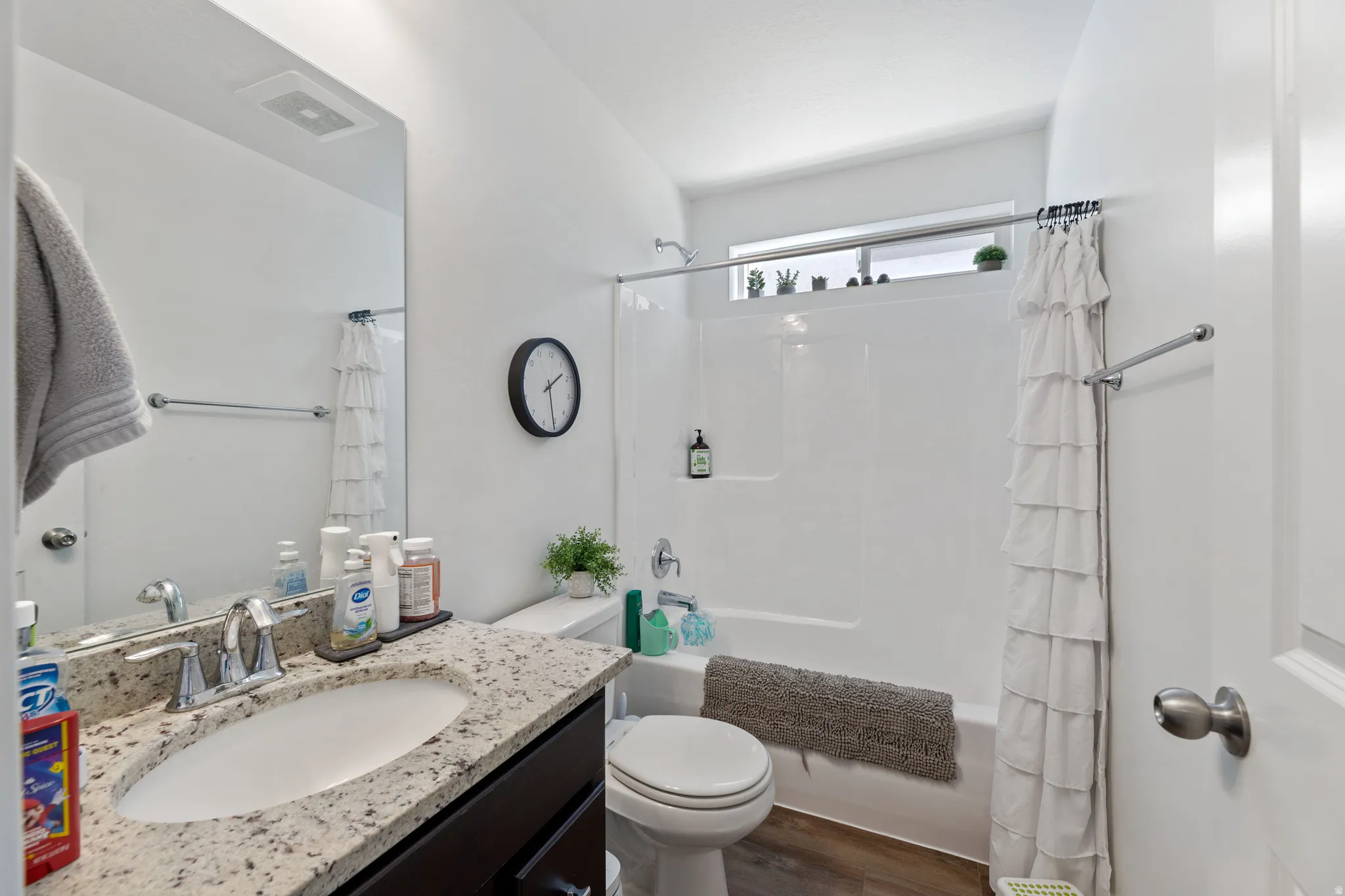 Bathroom featuring a single vanity with a light-toned speckled countertop, an undermount sink, and a chrome faucet