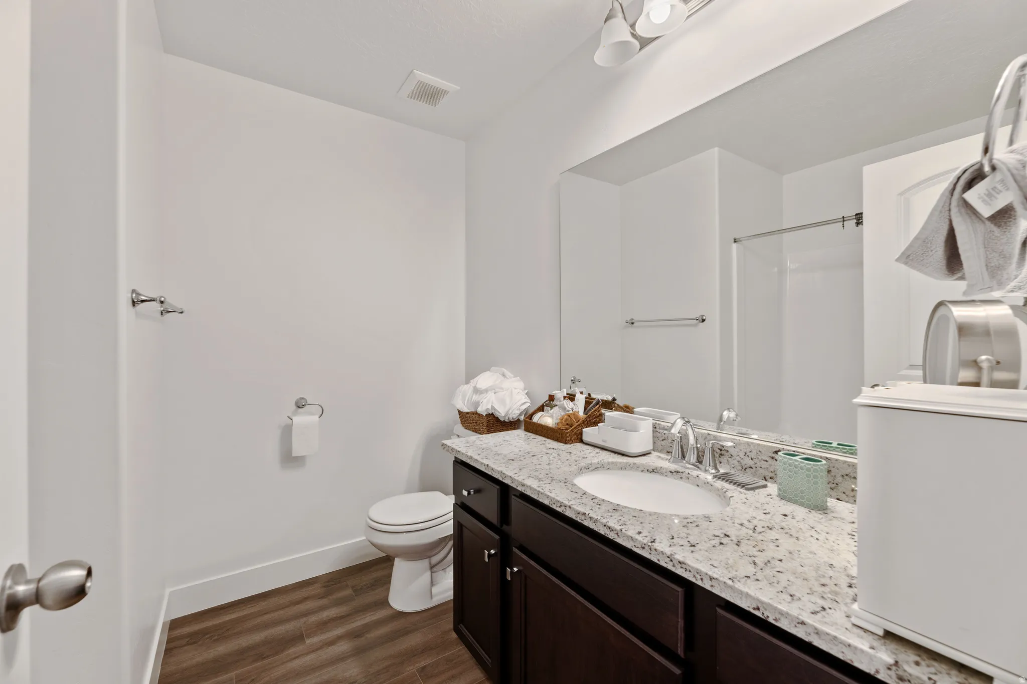 Bathroom featuring a full vanity with dark wood-finish cabinetry and a speckled stone countertop