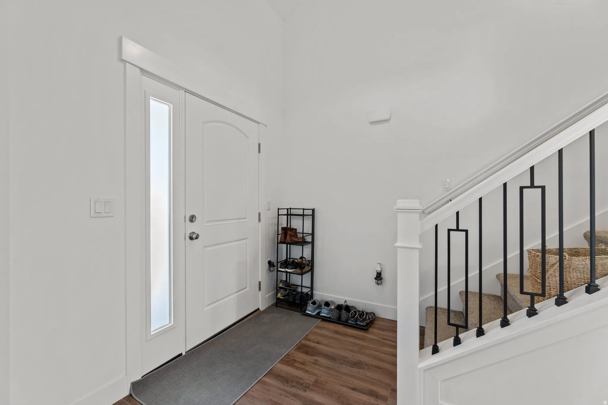 Entryway featuring a white paneled door with an arched top panel and a full-length frosted glass sidelight