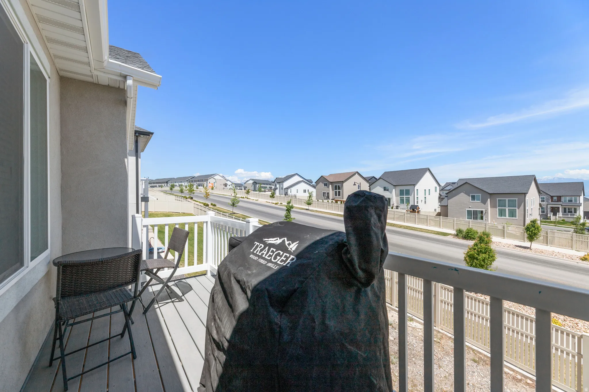 Exterior balcony with light gray decking and white railing