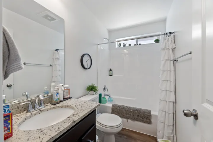 Bathroom featuring a single vanity with a light-toned speckled countertop, an undermount sink, and a chrome faucet
