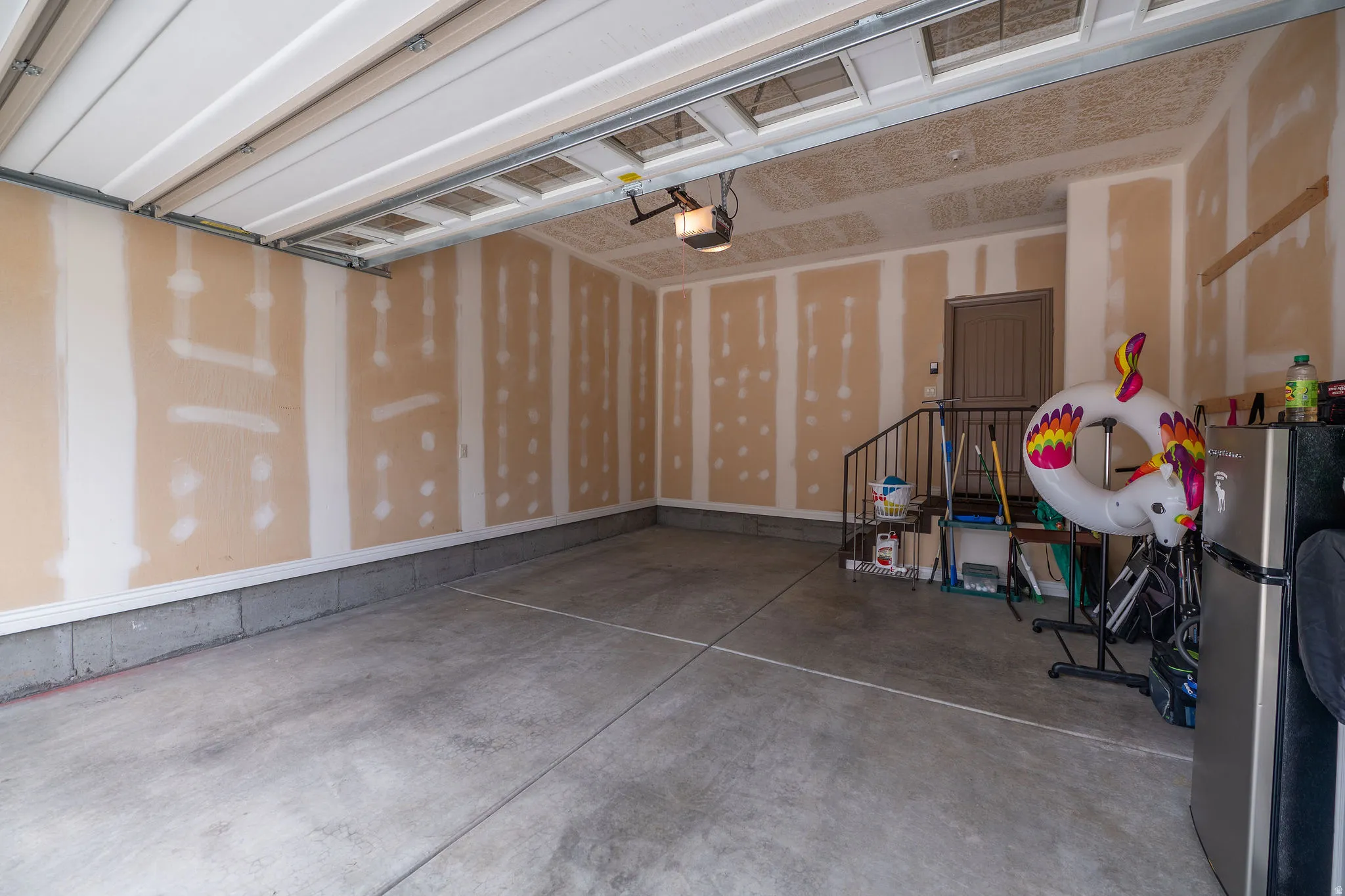Spacious two-car garage with drywalled walls, concrete floor, automatic opener, and direct interior access. Clean, open, and ready to work with.