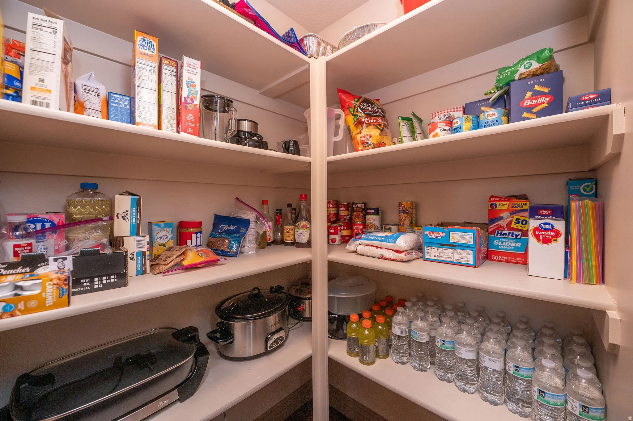 Spacious walk-in pantry with floor-to-ceiling shelving on multiple walls. Room for everything, and then some.