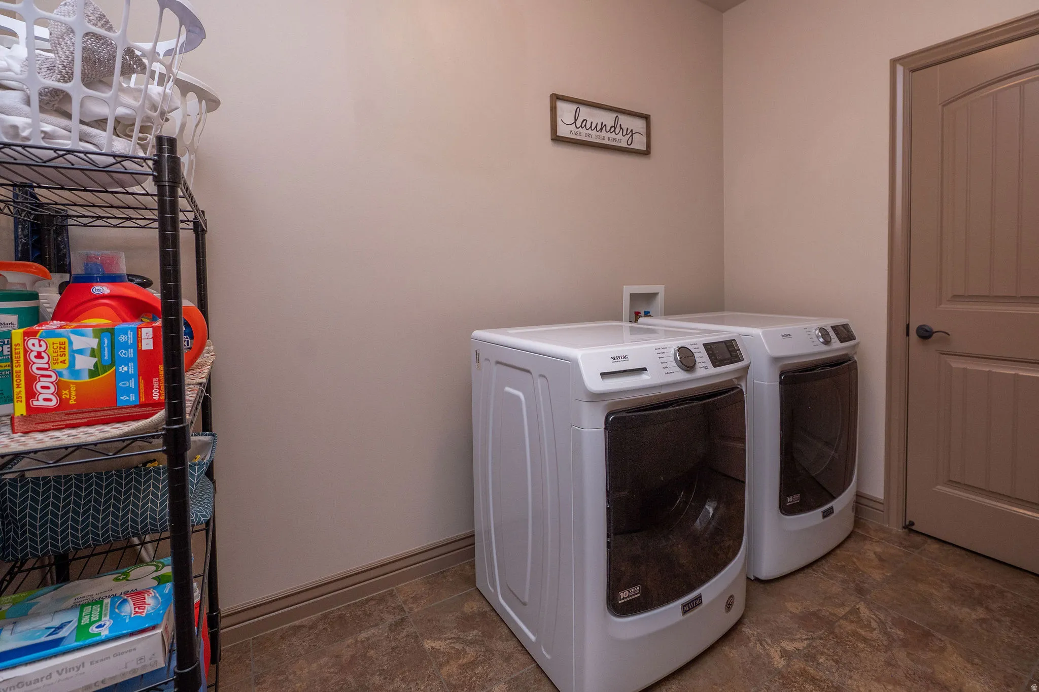 Dedicated laundry room with full-size Maytag front-load washer and dryer and tile flooring. Functional, roomy, and right where you need it.
