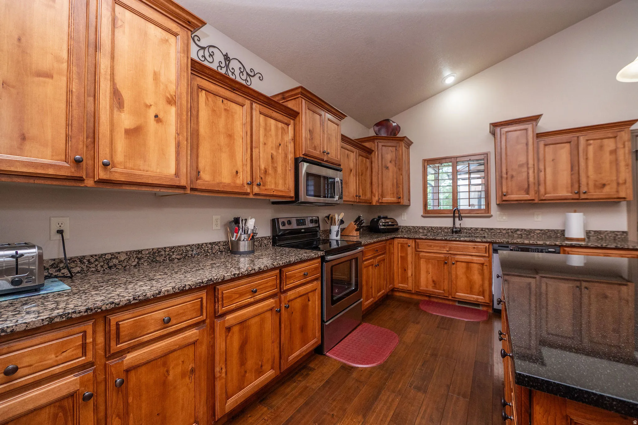 Floor-to-ceiling knotty alder cabinetry with rich granite counters and stainless appliances. Storage for days and style to match.