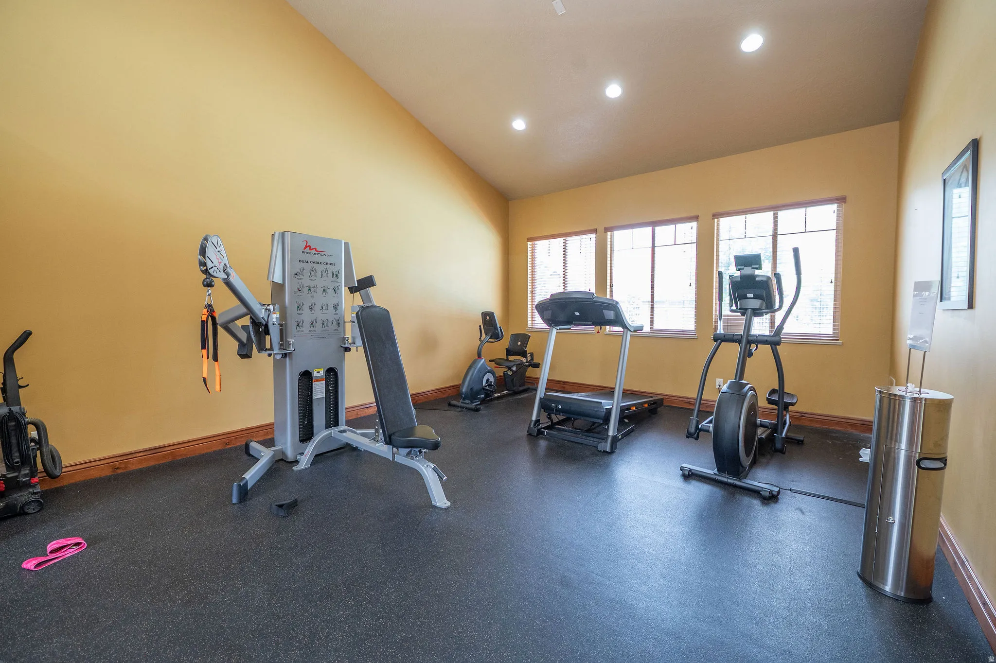 Well-equipped community fitness center with rubber flooring, cable machine, treadmill, elliptical, and stationary bike. Recessed lighting, vaulted ceilings, and natural light make this a space you'll actually want to use.