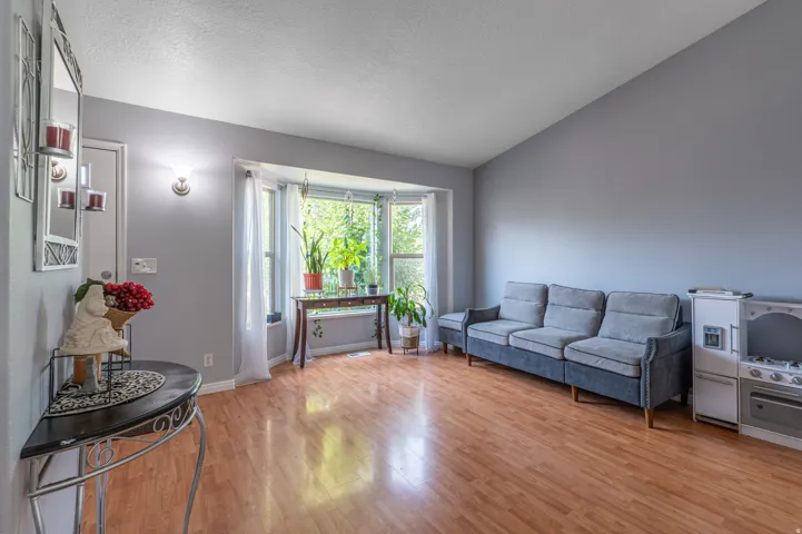 Living space featuring wood-finish flooring and a prominent bay window