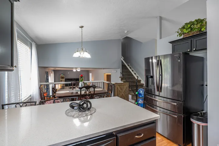 Kitchen island featuring a light-colored countertop, dark base cabinetry, and wood-finish flooring