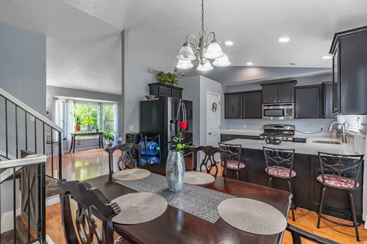 Kitchen and dining area featuring dark wood-finish cabinetry, light countertops, and stainless steel appliances