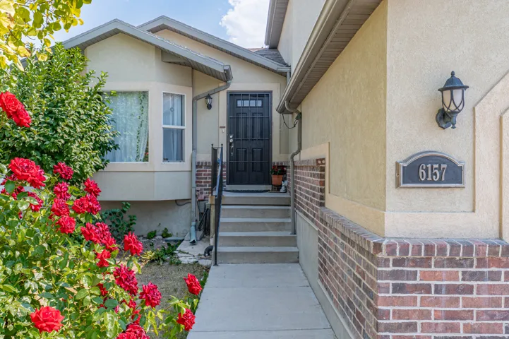 Stucco exterior featuring a brick facade and decorative address plaque