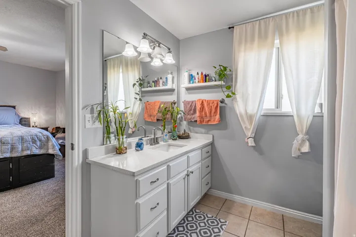 Master bathroom featuring a double vanity with white cabinetry, a light-toned countertop, and dual sinks