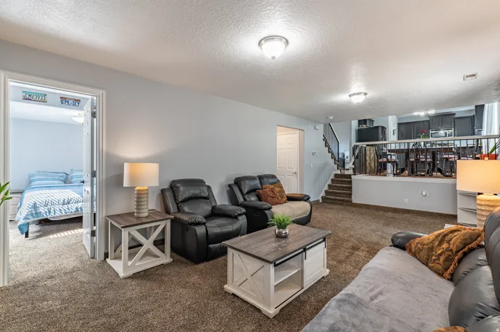 Spacious living area featuring neutral carpeting and light gray walls