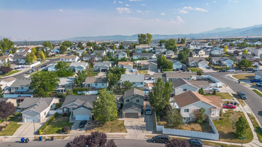 Expansive neighborhood featuring various single-family homes with pitched roofs, individual garages, and landscaped yards
