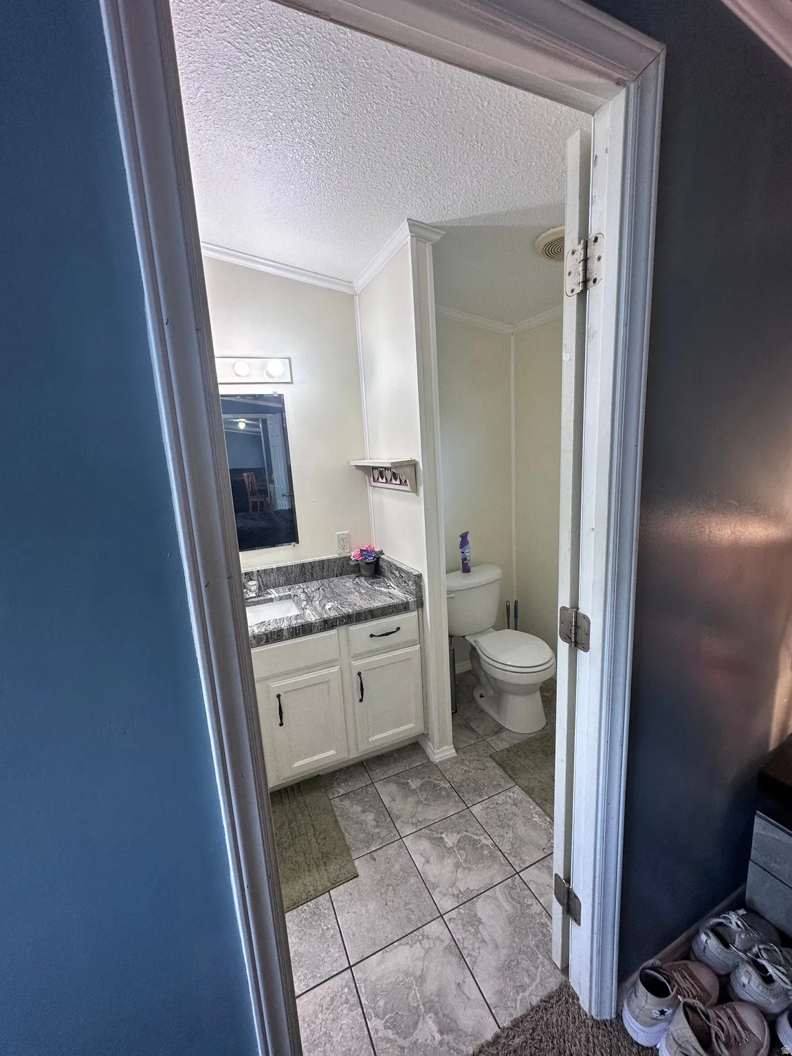 Bathroom featuring a vanity with a dark stone countertop, white cabinetry, and a rectangular sink