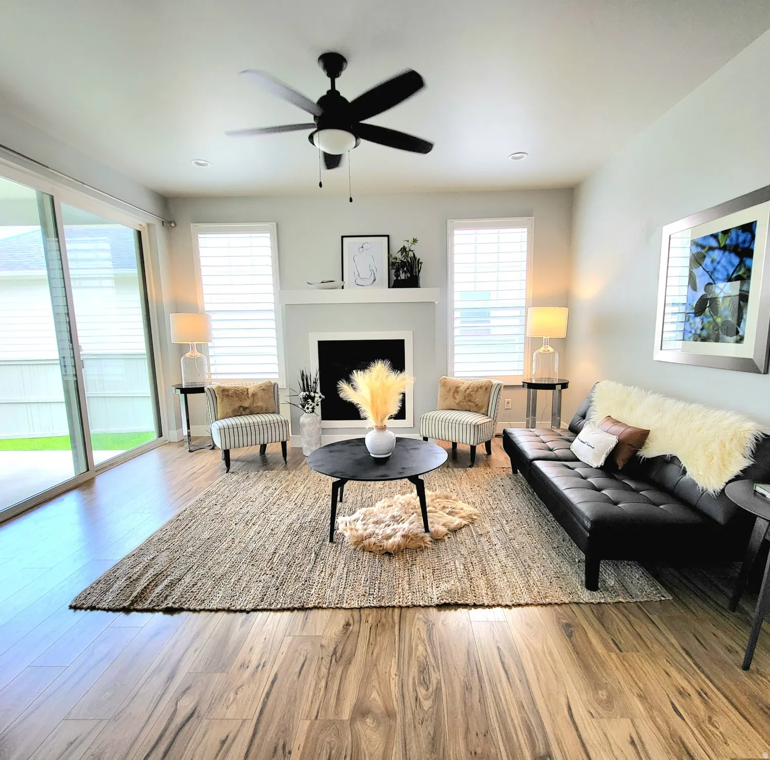 Living space featuring wood-finish flooring, a fireplace with a mantel, and recessed lighting