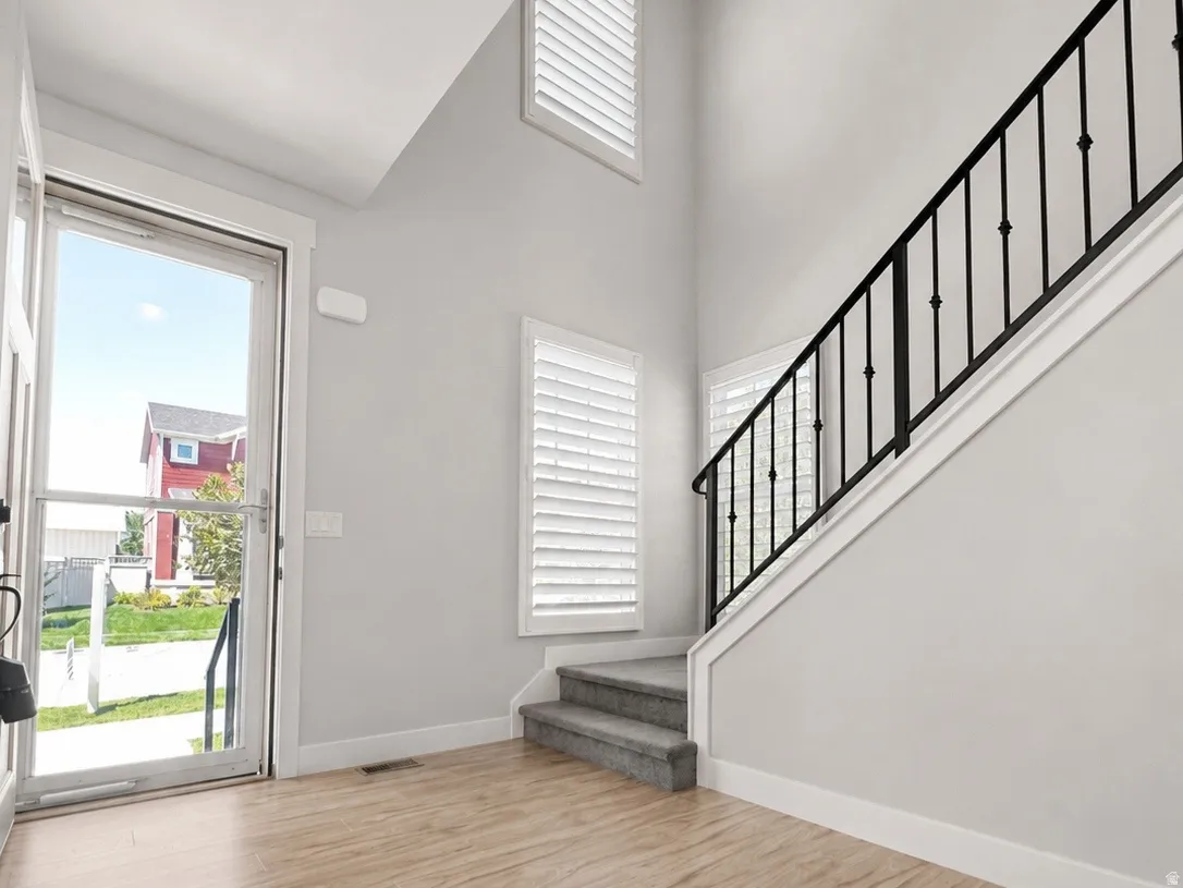Bright entry foyer featuring high ceilings and wood-finish flooring