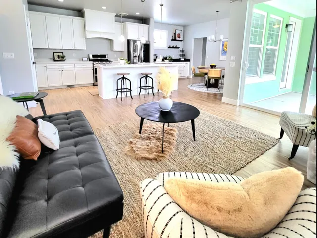 Open concept with living, kitchen, dining, leading to outside covered porch