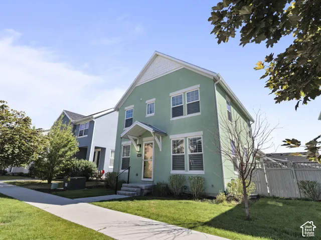 Two-story residence featuring light green stucco siding with white trim accents and Jellyfish lights