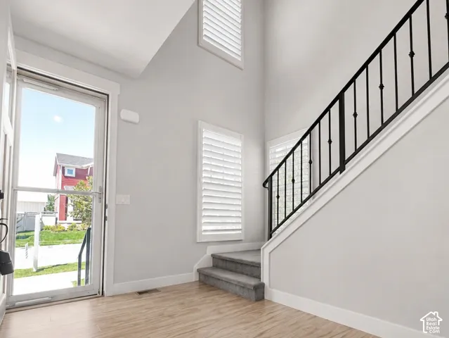 Bright entry foyer featuring high ceilings and wood-finish flooring