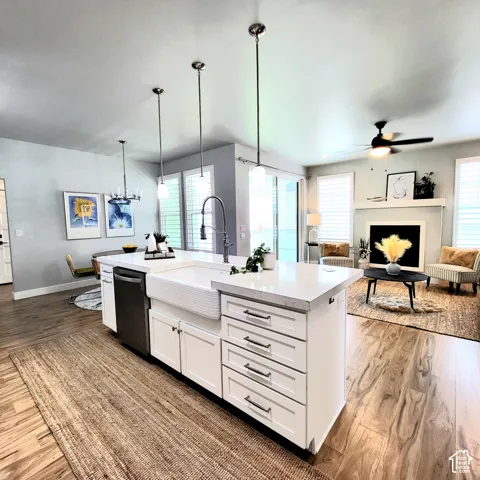 Kitchen island featuring a farmhouse sink, quartz countertop, and white cabinetry with dark pulls