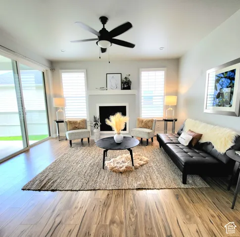 Living space featuring wood-finish flooring, a fireplace with a mantel, and recessed lighting