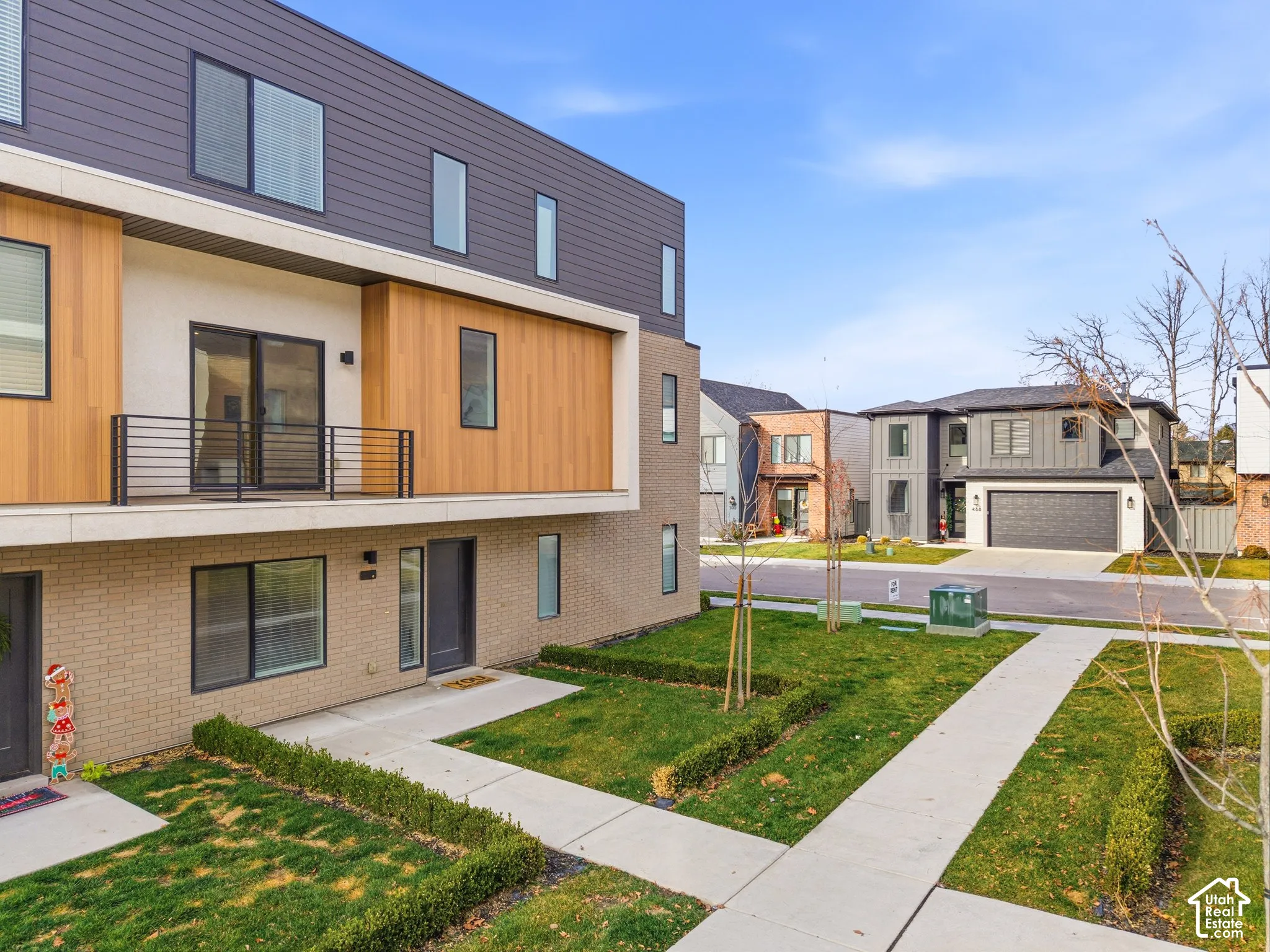 Contemporary multi-story exterior featuring a mix of brick, horizontal siding, and wood-finish paneling