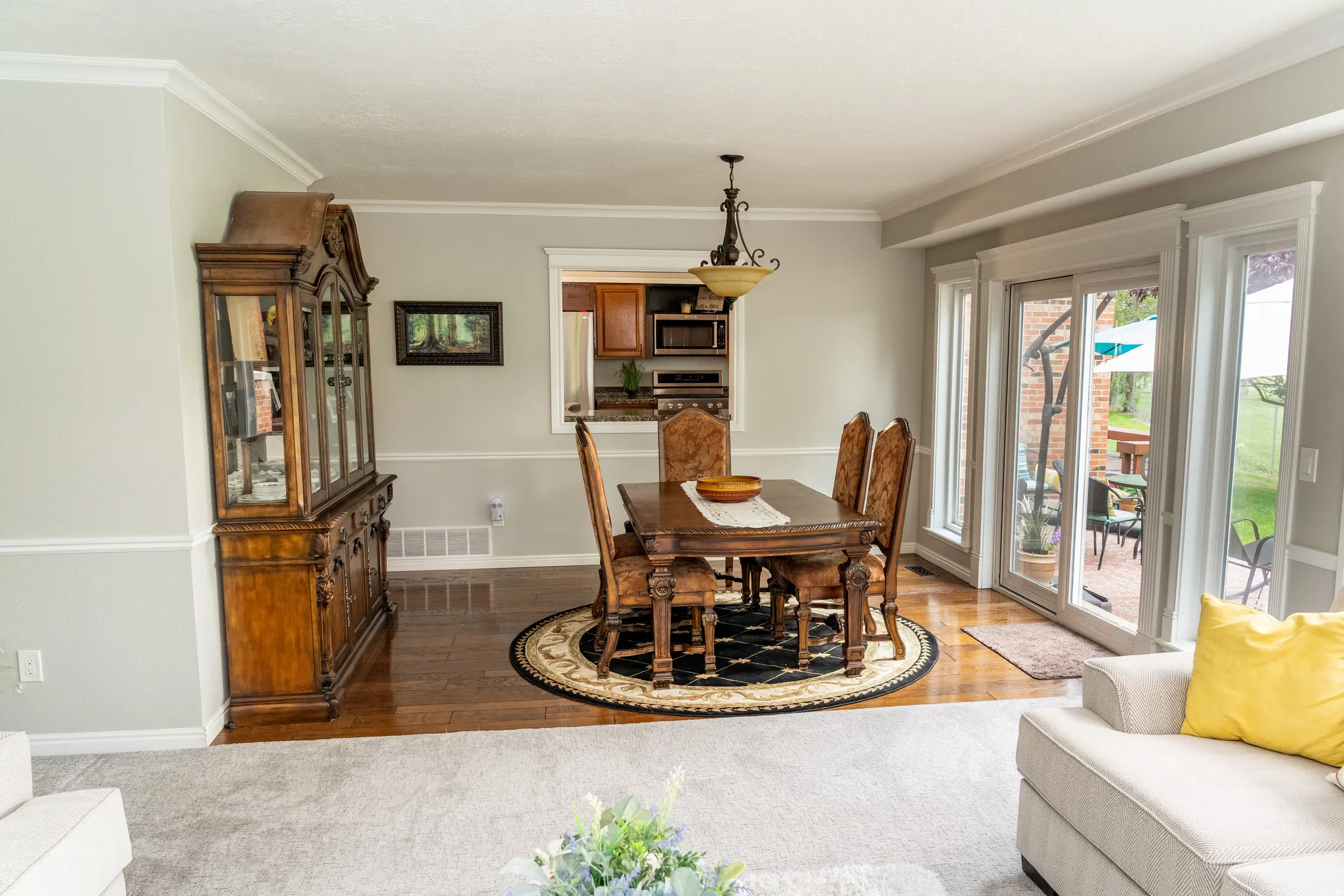 Dining area featuring wood-finish flooring, a decorative light fixture, and crown molding