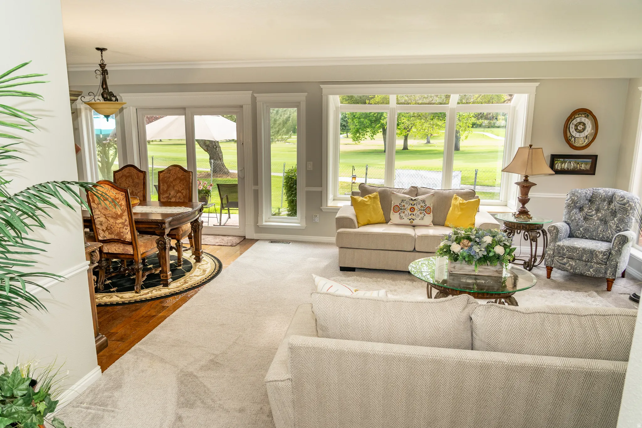 Spacious living room featuring a large bay window, light grey wall paint, and crown molding