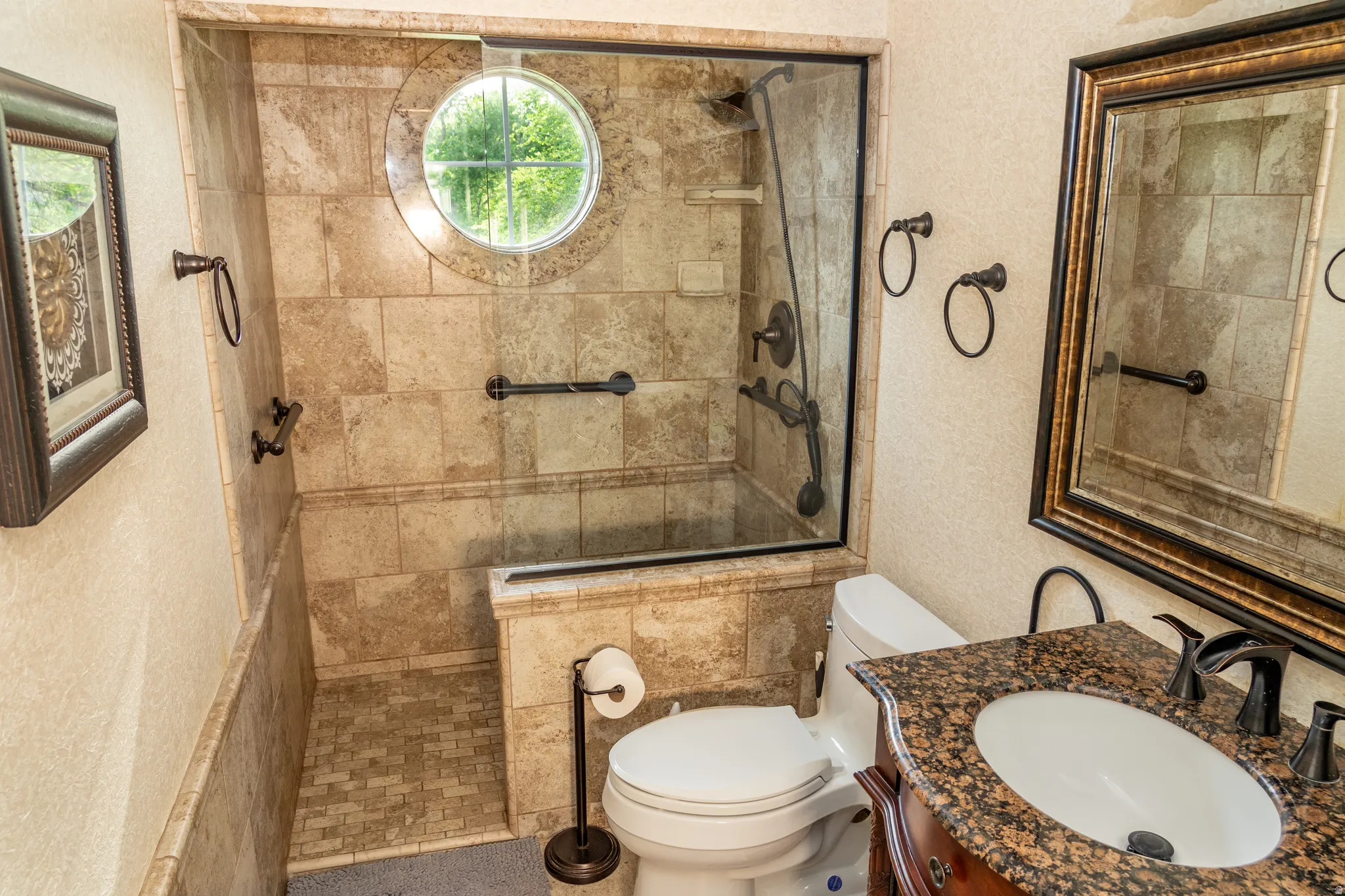 Walk-in shower with full-height tile surround and circular accent window