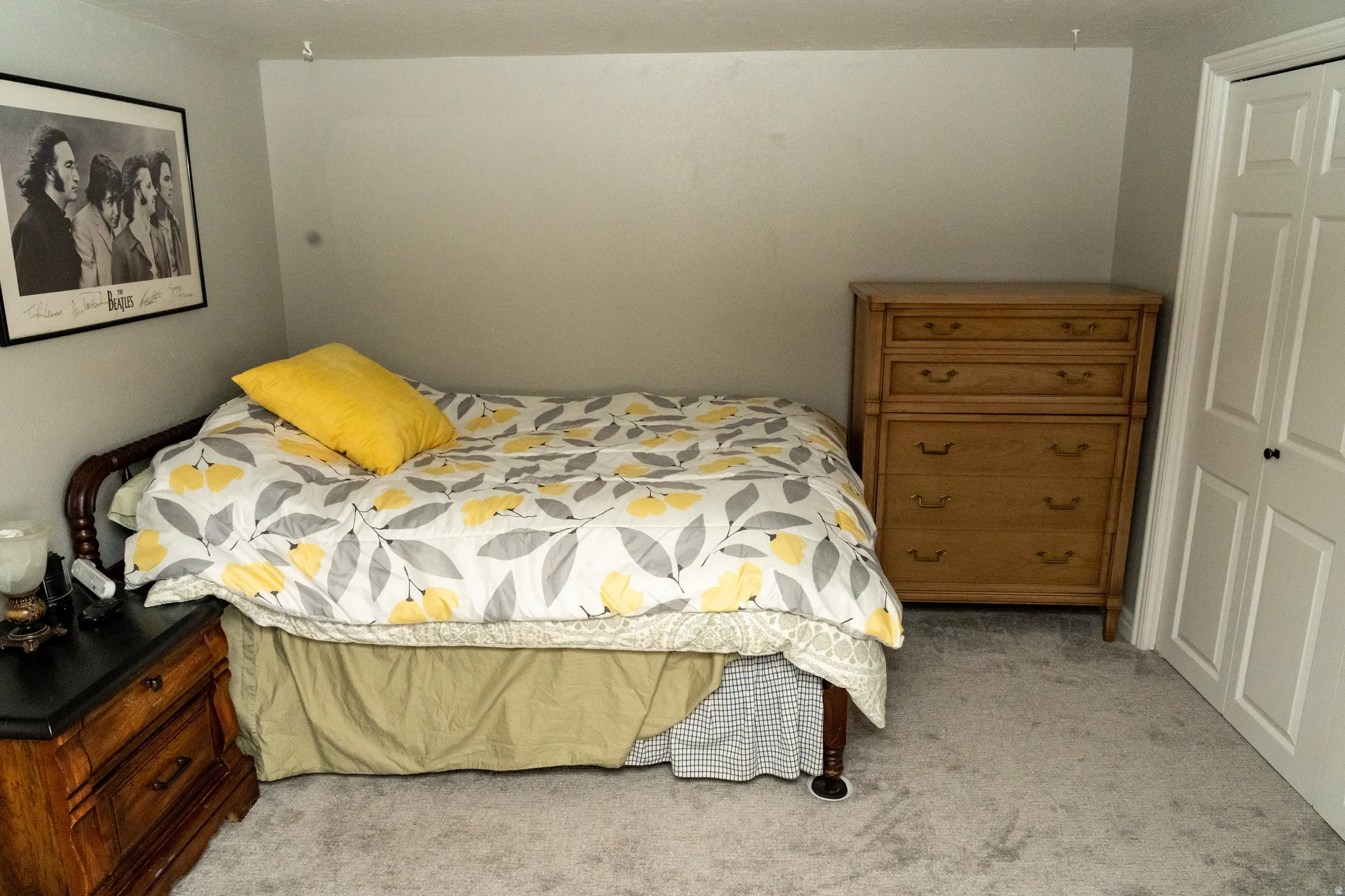 Bedroom featuring light gray walls, gray carpeting, and white bi-fold closet doors