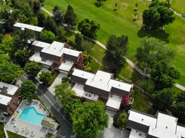 Townhome community featuring brick exteriors, white flat roofs, and attached garages
