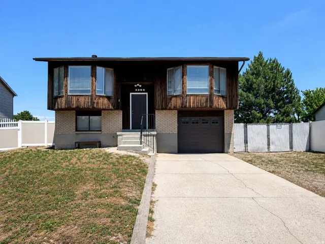 Split-level residence featuring a wood-panel and brick facade