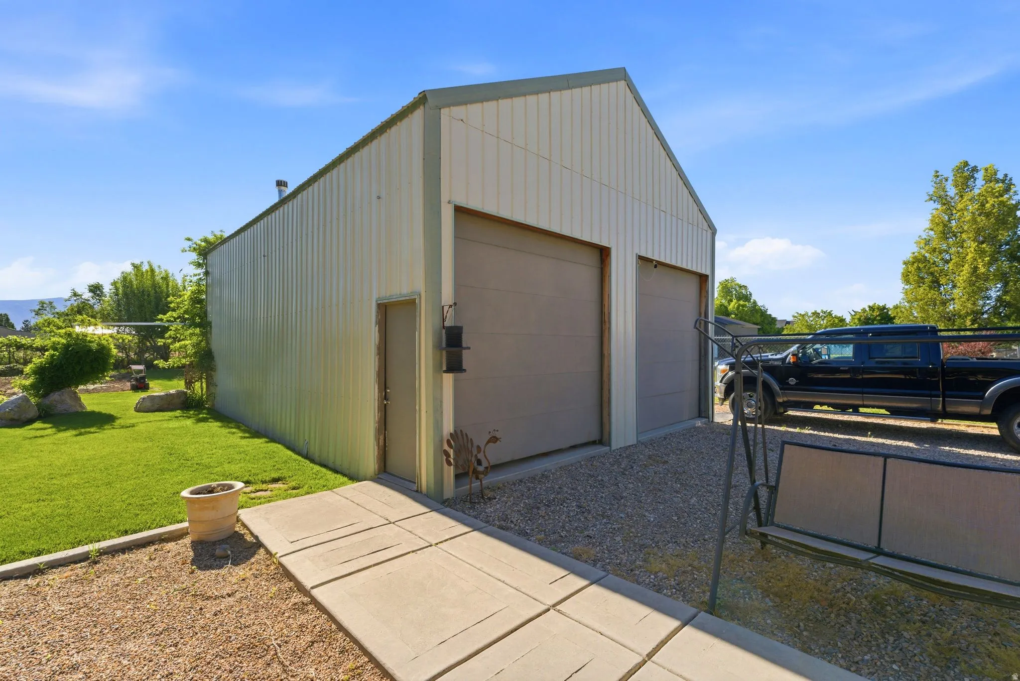 Detached two-bay garage structure with a gabled roof and light-colored metal siding