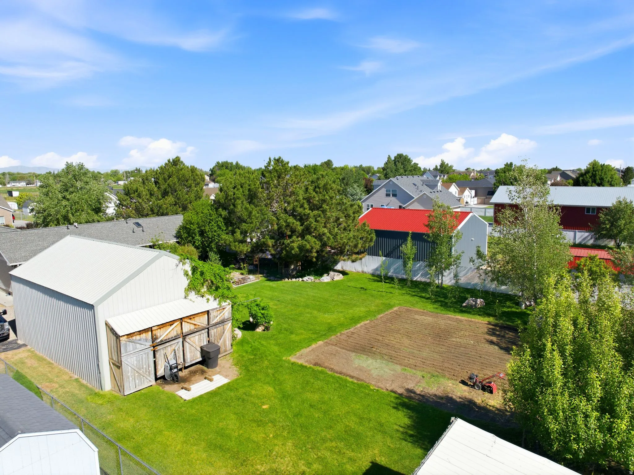 Expansive green space featuring a large tilled garden area