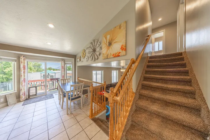 Carpeted staircase with wood banister and railing