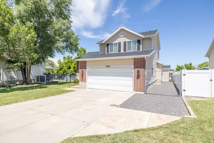 Two-story property featuring a front-facing garage with a concrete driveway